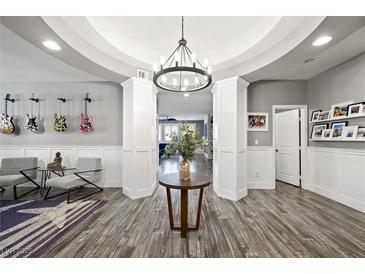 Stunning entryway with an open archway, wood floors, statement lighting, and artistic guitar decor at 2365 Boretto St, Henderson, NV 89044