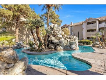 Inviting community pool with a waterfall feature and landscaping at 4200 S Valley View Blvd # 1083, Las Vegas, NV 89103