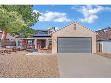 Single-story home with grey garage door and landscaped yard at 5420 Doe Ave, Las Vegas, NV 89146