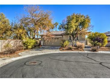 Tan house with a two-car garage and mature landscaping at 5744 Serenity Haven St, North Las Vegas, NV 89081