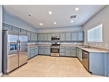 Well-lit kitchen featuring stainless steel appliances and gray cabinets at 5555 Sun Temple Ave, Las Vegas, NV 89139