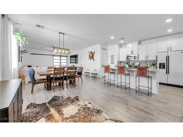 Open concept dining area with wood table and modern lighting at 6318 Amber Sunrise St, North Las Vegas, NV 89031