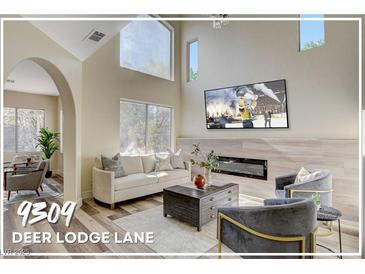 Spacious living room featuring a modern fireplace and large TV at 9309 Deer Lodge Ln, Las Vegas, NV 89129