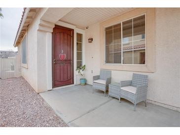 Inviting front porch with two wicker chairs and a small table at 10605 Moon Flower Arbor Pl, Las Vegas, NV 89144