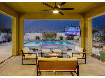 Relaxing backyard with a sparkling pool, patio furniture, and fire pit at 2576 Desante Dr, Henderson, NV 89044