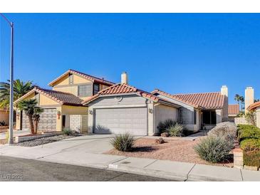 Two-story house with Spanish tile roof, attached two-car garage, and desert landscaping at 321 Carrington St, Henderson, NV 89074