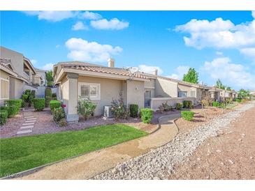 Landscaped backyard with gravel pathway, green grass, and desert landscaping at 3236 Mystic Ridge Ct, Las Vegas, NV 89129