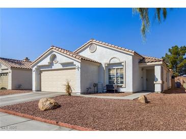 Single-story house with beige exterior, two-car garage, and landscaped front yard at 3327 Outlook Point St, North Las Vegas, NV 89032