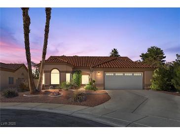 Single-story house with tan walls, tile roof, and a two-car garage at 4609 Snowpoint Ct, Las Vegas, NV 89130