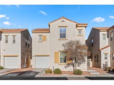 Two story house with tan exterior, white garage door, and landscaping at 5400 Flowing Spring St, Las Vegas, NV 89122