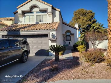 Two-story house with gray garage door and landscaping at 8416 Shore Breeze Dr, Las Vegas, NV 89128