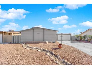 Ranch style home with gray exterior, landscaped yard, and a long driveway at 905 Antelope Way, Las Vegas, NV 89145