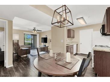 Open living room with dark wood floors, and a view into the kitchen and dining area at 950 Seven Hills Dr # 2413, Henderson, NV 89052