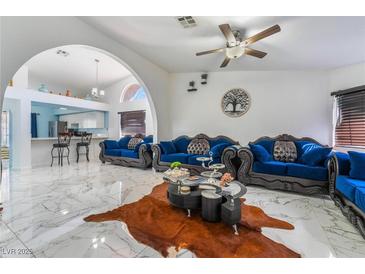 Spacious living room with marble floors and stylish blue velvet furniture at 1431 Di Blasi Dr # 105, Las Vegas, NV 89119