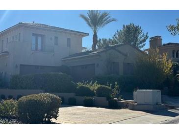 Beautiful multi-story home with a lush landscaped yard and an attached garage at 312 N Royal Ascot Dr, Las Vegas, NV 89144