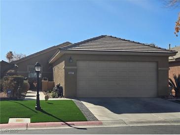 Single-story house with attached garage and landscaped front yard at 5697 Crowbush Cove Pl, Las Vegas, NV 89122