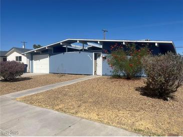 Ranch style home with blue exterior, landscaped yard, and attached garage at , Las Vegas, NV 89107