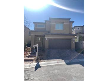 Two-story home with a stucco exterior, a brick paved driveway, and a two car garage at 12381 Foxtail Run Ave, Las Vegas, NV 89138