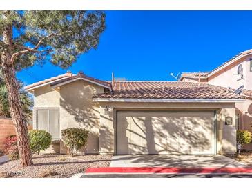 Tan stucco house with a two-car garage and desert landscaping at 1473 Teddington Ct # 101, Las Vegas, NV 89102