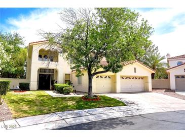 Two-story house with attached two-car garage, landscaping, and a tree in the front yard at 1813 Francisco Peak Pl, Las Vegas, NV 89128