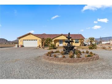 Single-story home with a fountain and landscaped yard at 3720 W Charleston Park Ave, Pahrump, NV 89048