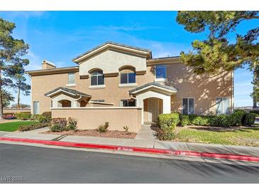 Tan two-story townhome with a landscaped yard and two-car garage at 503 Fragrant Orchard St, Henderson, NV 89015