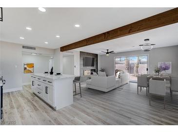 Open floor plan boasts modern kitchen island and spacious living area with fireplace at 6252 Fairwood Ave, Las Vegas, NV 89107