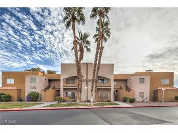 Tan two-story building with palm trees and red curb at 6861 Tamarus St # 203, Las Vegas, NV 89119