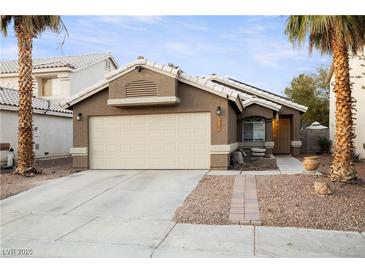 Single-story house with a two-car garage and landscaped front yard at 7336 Young Doe Ave, Las Vegas, NV 89130