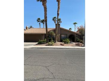 Single story home with tile roof, attached garage, and landscaped front yard at 7509 W Gilmore Ave, Las Vegas, NV 89129