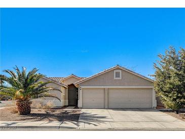 Tan house with two-car garage and desert landscaping at 641 Brad St, Henderson, NV 89015