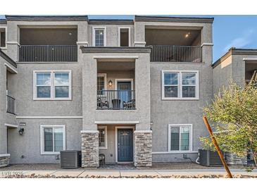 Two-story townhome with gray exterior, stone accents, and private balcony at 6521 Taffrail Ave, Las Vegas, NV 89118