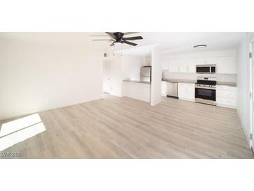 Open living room with kitchen, stainless steel appliances, and light wood flooring at 4480 Sandy River Dr # 64, Las Vegas, NV 89103