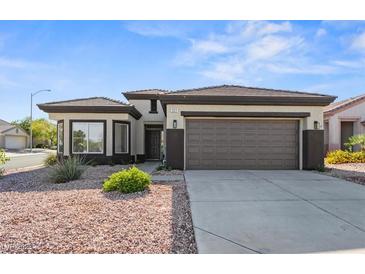 Single-story home with a two-car garage and desert landscaping at 511 Dalgreen Pl, Henderson, NV 89012