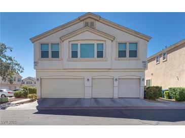 Three-story townhome with three-car garage and landscaped front at 8627 Roping Rodeo Ave # 103, Las Vegas, NV 89178