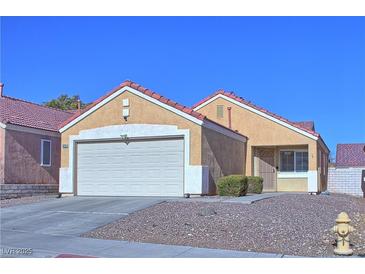 Tan one-story house with a two-car garage and landscaped yard at 8836 Big Bear Pines Ave, Las Vegas, NV 89143