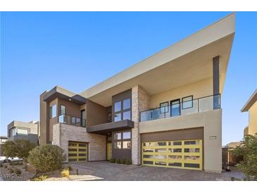 Modern two-story home with yellow garage doors and landscaped yard at 10955 Mojave Spring Dr, Las Vegas, NV 89135