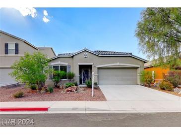 Tan one-story house with a two-car garage and landscaped yard at 1153 Pine Cove Ct, Henderson, NV 89011