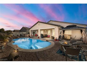 Desert landscape with sparkling pool, covered patio & firepit at 2540 Sparrow Way, Pahrump, NV 89048