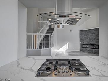 Modern kitchen featuring stainless steel appliances, a sleek range hood, and white marble countertops at 5236 Woodlawn Ln, Las Vegas, NV 89130