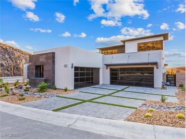 Modern home with two-car garage and landscaped front yard at 591 Overlook Rim Dr, Henderson, NV 89012