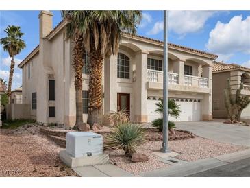 Two-story house with a large driveway and palm trees at 9852 Snowy Canyon Ct, Las Vegas, NV 89183