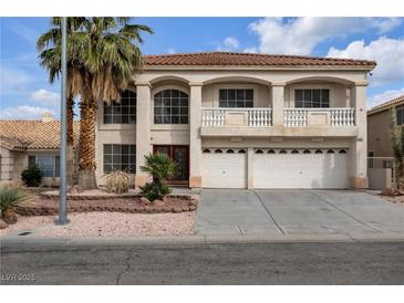 Two-story house with balcony, attached garage, and landscaping at 9852 Snowy Canyon Ct, Las Vegas, NV 89183