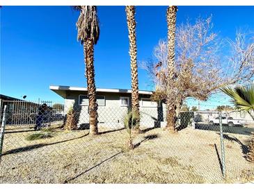 Ranch style home with a fenced yard and mature palm trees at 99 N 21St St, Las Vegas, NV 89101