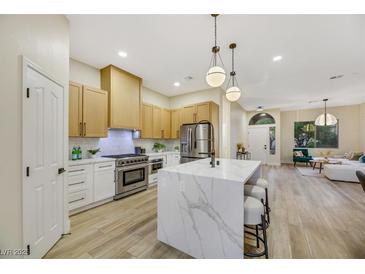 Modern kitchen with white cabinets, marble island, and stainless steel appliances at 10369 Niagara Falls Ln, Las Vegas, NV 89144