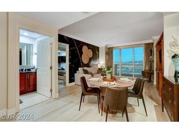 Bright dining area with a wooden table and four chairs, offering city views at 145 E Harmon Ave # 2120, Las Vegas, NV 89109