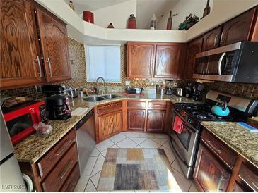 Well-equipped kitchen featuring granite countertops and ample wood cabinetry at 3830 Passionfruit St, North Las Vegas, NV 89032