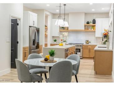 Modern kitchen with island, stainless steel appliances, and light wood cabinets at 62 Incline Village Ct, Henderson, NV 89074