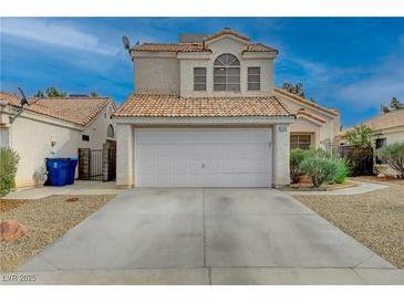 Two-story house with a white garage door and desert landscaping at 7214 Paradise Bay Dr, Las Vegas, NV 89119