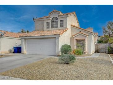 Two-story home features a tile roof, attached two car garage, and desert landscaping at 7214 Paradise Bay Dr, Las Vegas, NV 89119